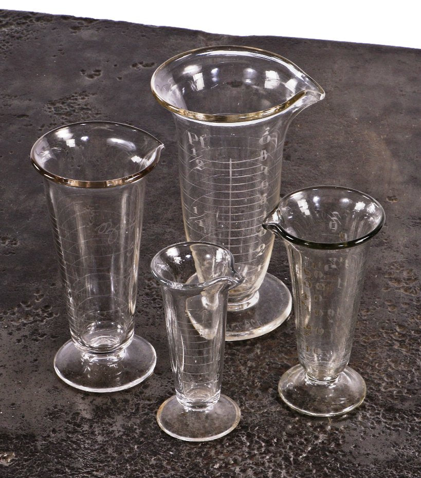 assortment of original early 20th century antique american medical wheel-cut etched glass fanciful pharmaceutical conical-shaped glass measures with pedestal bases