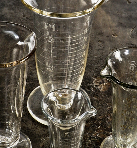 assortment of original early 20th century antique american medical wheel-cut etched glass fanciful pharmaceutical conical-shaped glass measures with pedestal bases