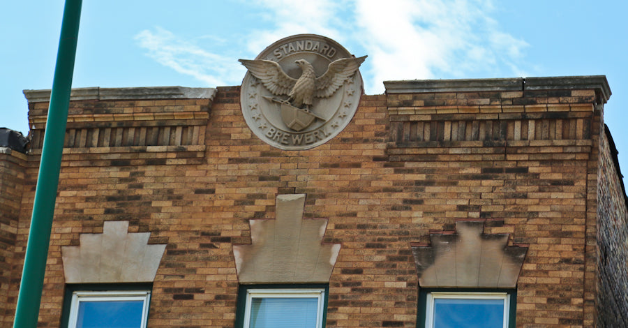 two original matching elegantly designed early 20th century standard brewery corner saloon carved limestone exterior roofline brackets or corbels with age appropriate wear