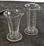 set of two all original and intact american antique lightly etched heavy clear glass drugstore apothecary measures with weighted round bases