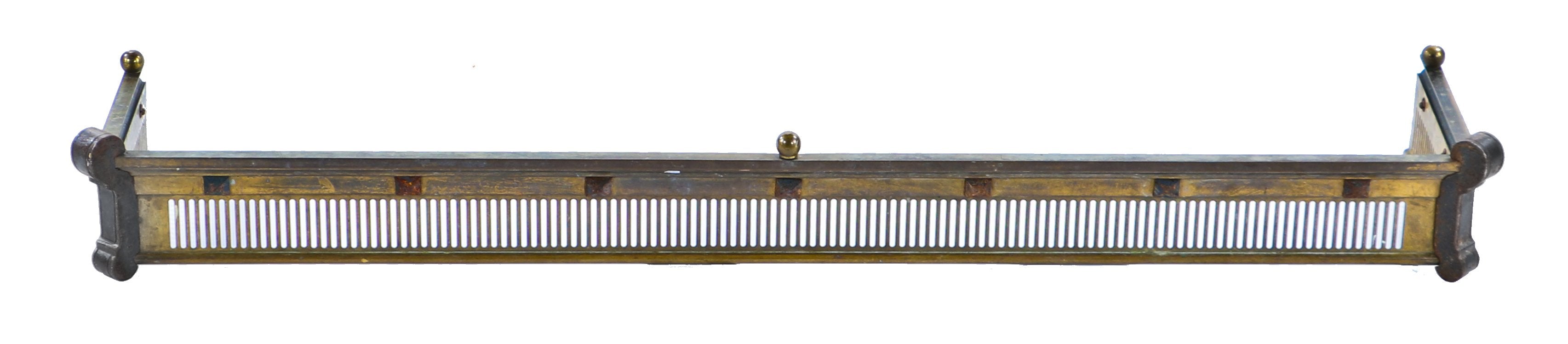 single oversized late 19th or early 20th century brass and iron interior residential ornamented fireplace hearth surround or fender with opposed volutes