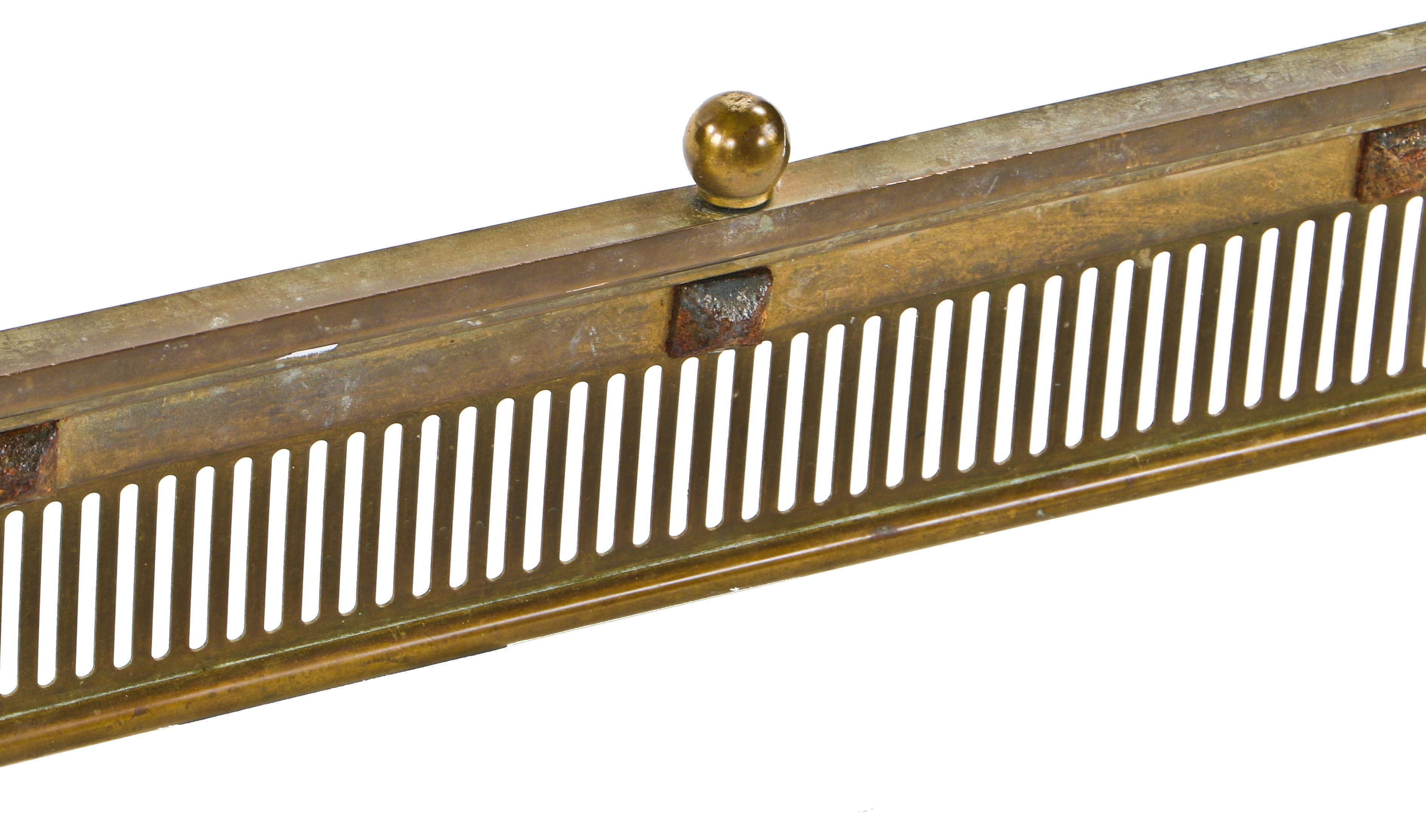 single oversized late 19th or early 20th century brass and iron interior residential ornamented fireplace hearth surround or fender with opposed volutes