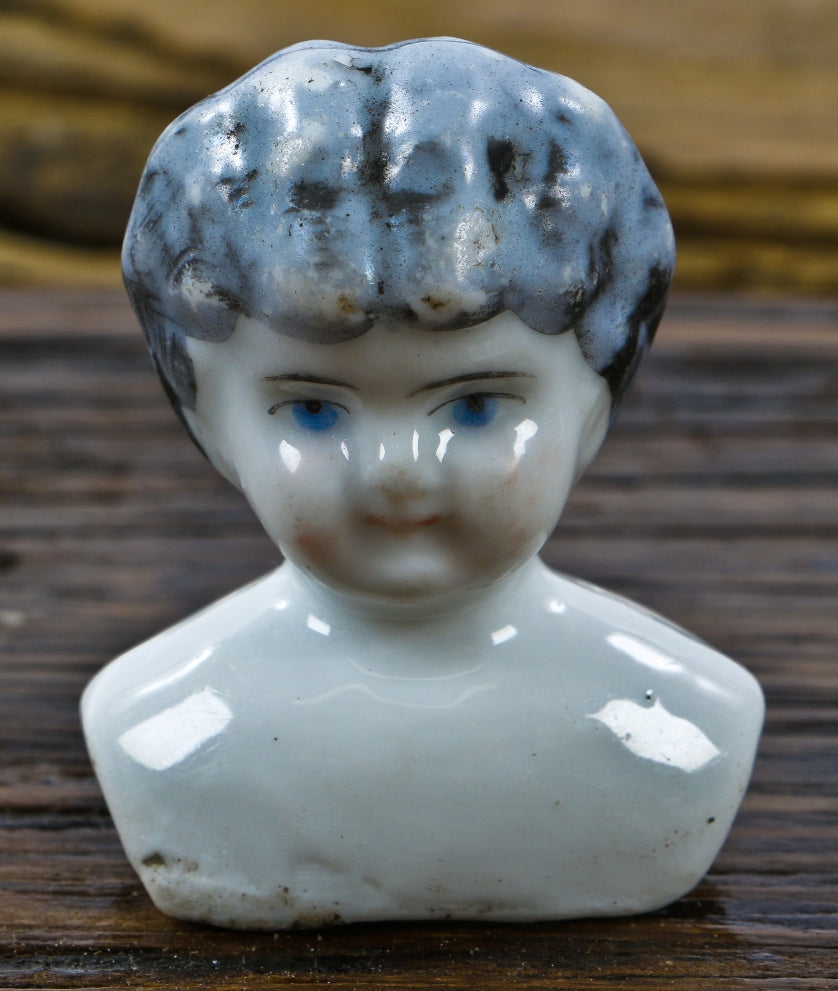 original and antique nineteenth century "frozen charlotte" or bathing baby porcelain doll head dug from a chicago area demolition site