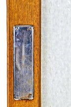 one of two matching original original early 20th century varnished golden oak wood residential pantry swinging door with intact large "florentine" pattern privacy glass pane