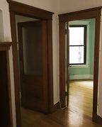 one of two matching original original early 20th century varnished golden oak wood residential pantry swinging door with intact large "florentine" pattern privacy glass pane
