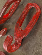 group of four nicely distressed oversized late 19th or early 20th century hand-forged wrought iron red painted interlocking hooks from a factory or farmstead