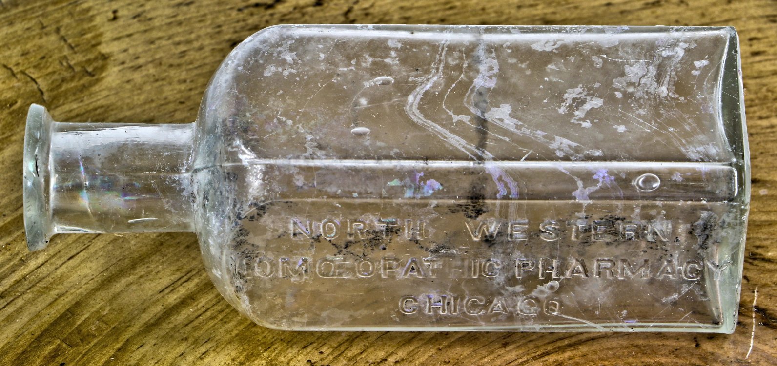 original and intact late nineteenth century privy dug hand blown colorless glass medicine bottle fabricated for northwestern homeopathic pharmacy in chicago, il.