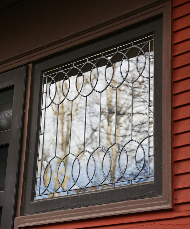 important late 19th century strongly geometric leaded clear glass robert p. parker "bootleg" house window featuring bands of overlapping ovals
