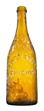 exceptionally rare antique american mid-nineteenth century privy dug vibrant yellow colored champagne style beer bottle with applied ring fabricated for the chicago bottlers the lang brothers.