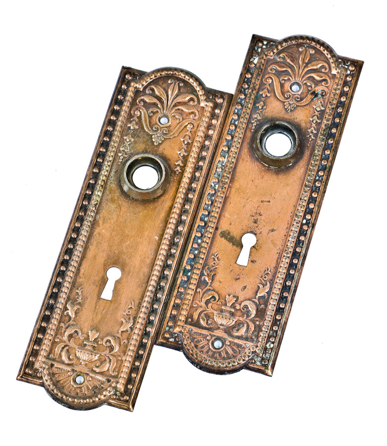original and intact early 20th century copper-plated stamped steel "como" pattern antique american interior residential passage door backplates