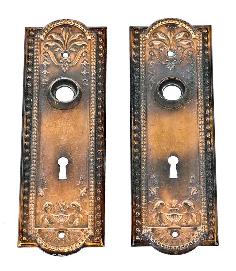 c. 1910 matching ornamental interior residential "como" pattern stamped steel passage door escutcheons or backplates with oxidized copper-plated finish