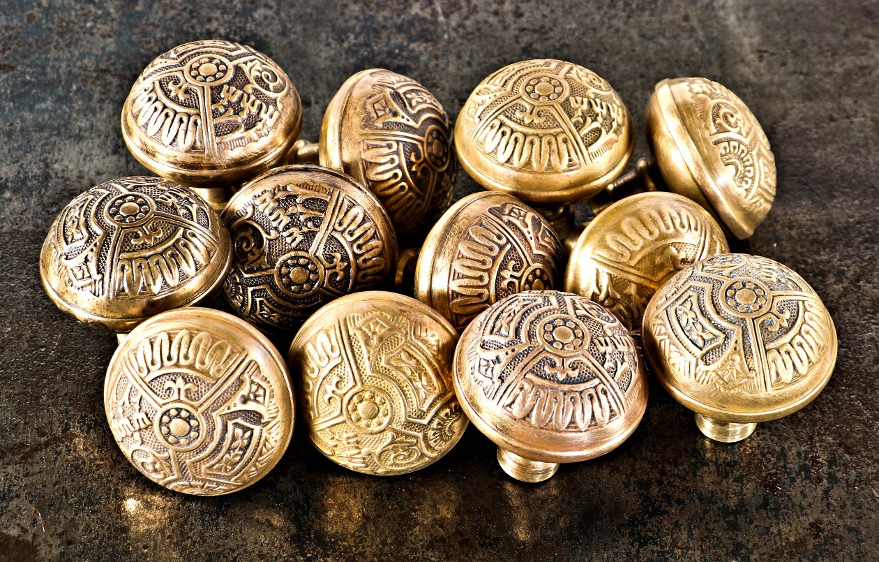 twelve matching highly sought after all original late 19th century american eastlake style "ceylon" pattern wrought brass dome-shaped doorknobs with banded rims