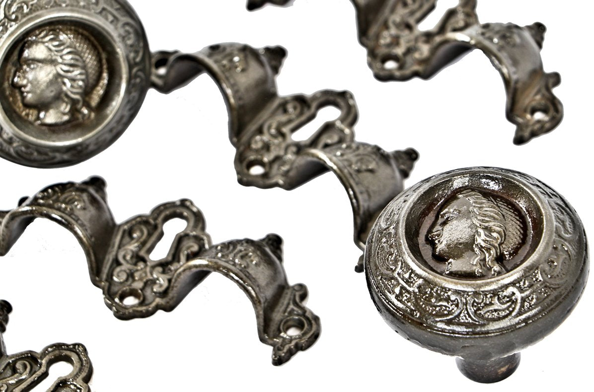 four matching original and completely intact refinished ornamental cast iron druggists' cabinet drawer pulls with centrally located keyholes