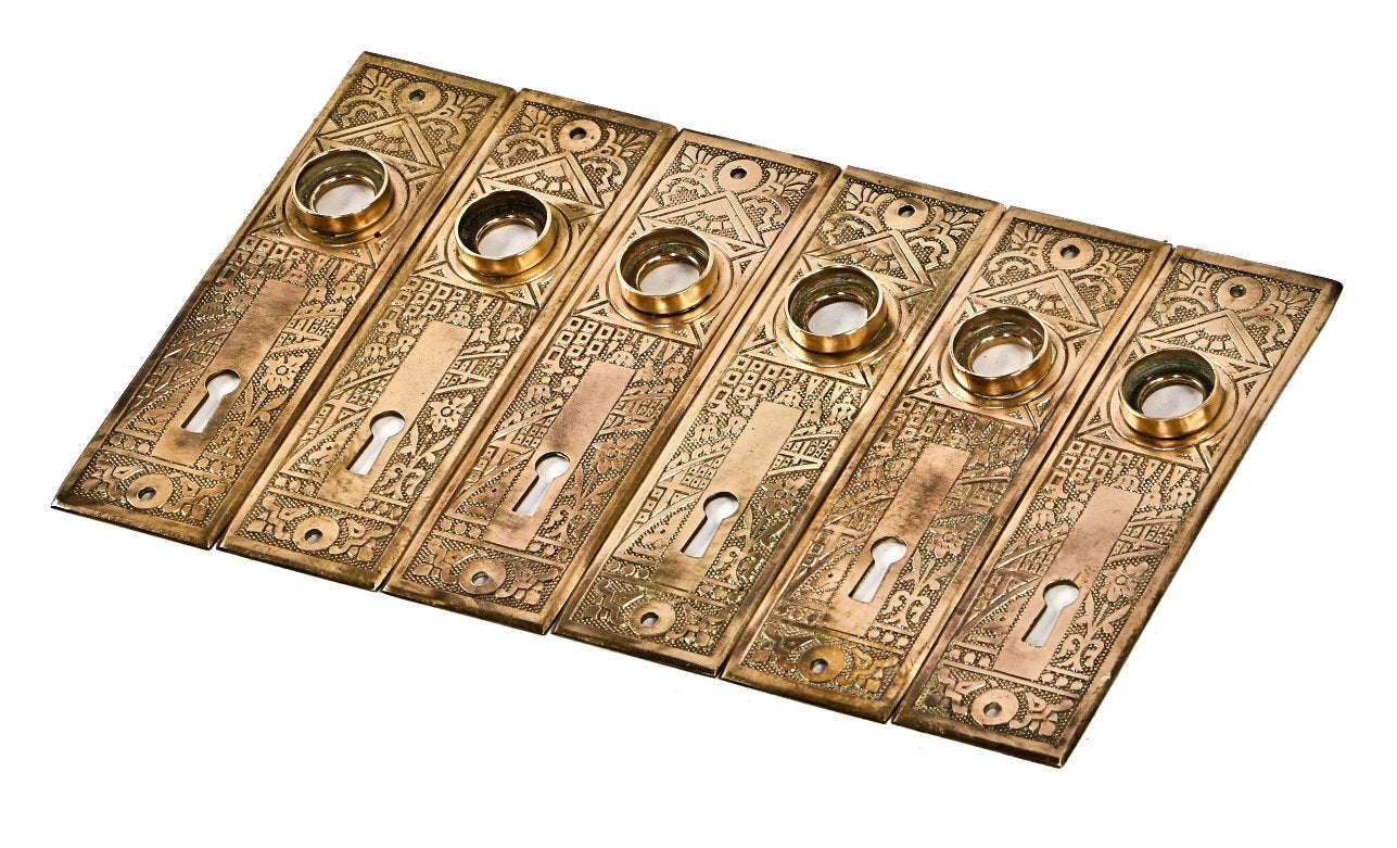 six matching original highly desirable american 1880's eastlake style stamped wrought brass "ceylon" pattern interior residential doorknob backplates or escutcheons
