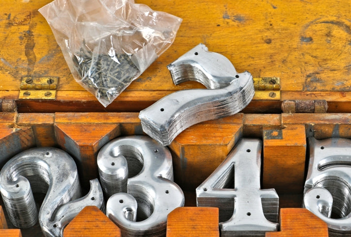 rare early 20th century antique american industrial "new old stock" stamped metal residential or commercial address numbers with box and nails