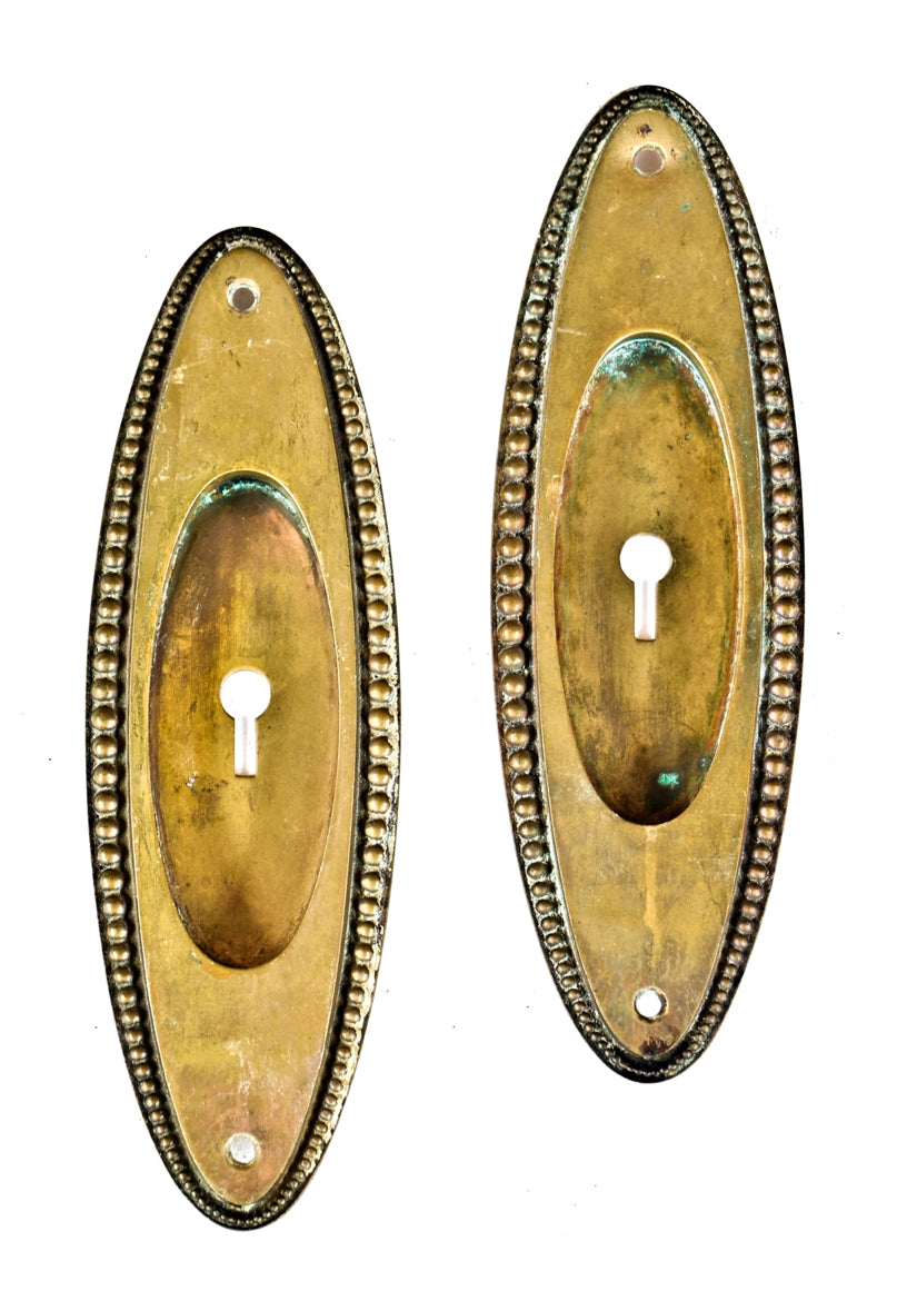 set of four matching early 20th century oval-shaped beaded border cast brass salvaged chicago interior residential pocket door backplates