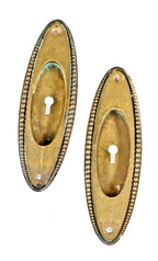 set of four matching early 20th century oval-shaped beaded border cast brass salvaged chicago interior residential pocket door backplates
