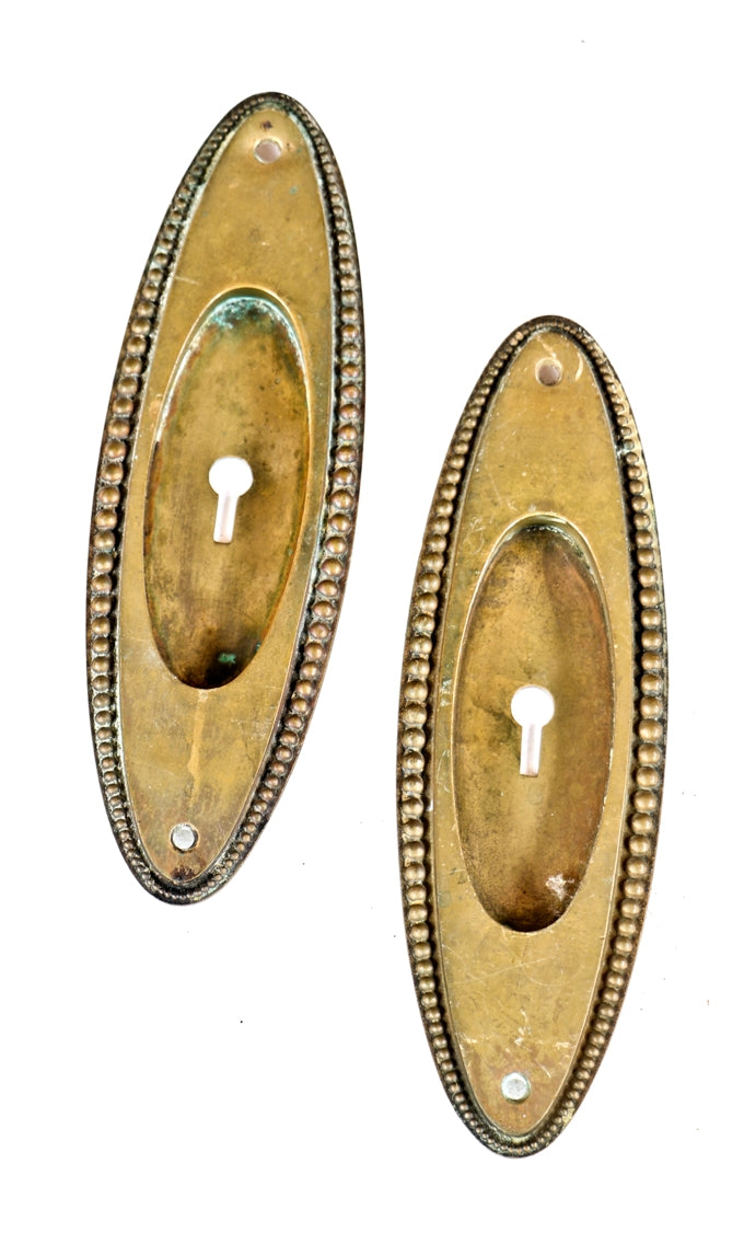 set of four matching early 20th century oval-shaped beaded border cast brass salvaged chicago interior residential pocket door backplates
