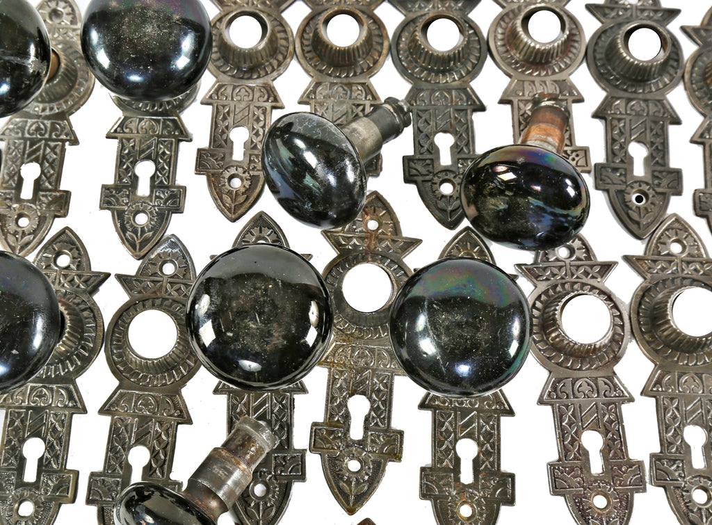 several matching sets of original 1880's salvaged chicago "jet black" niles patented screwless spindle doorknobs and matching ornamental cast iron backplates