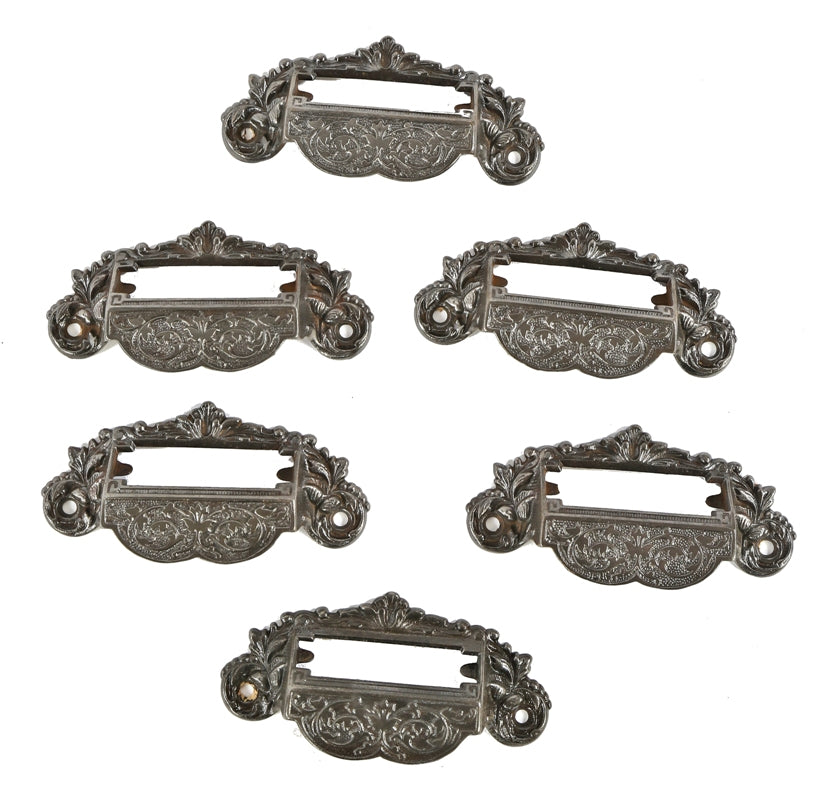 group of six matching 19th century american ornamental cast iron interior apothecary or drugstore wall cabinet drawer handles with openings for labels
