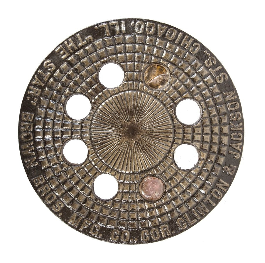 original 19th century city of chicago commercial building ornamented cast iron sidewalk coal chute circular-shaped cover with a multitude of holes once containing glass vault lenses