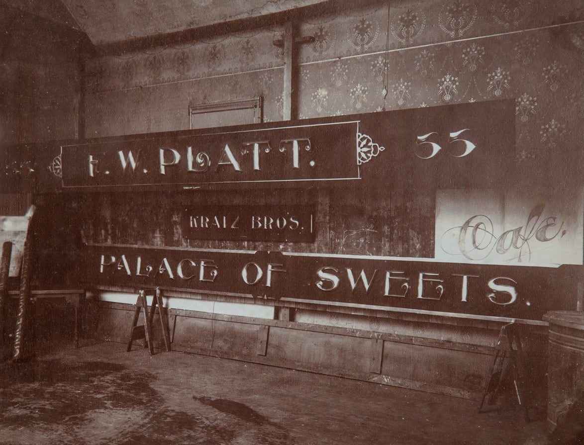 rare original and intact late 19th or early 20th century sepia-toned gelatin silver print of a building sign shop studio interior located in or around winona, minnesota