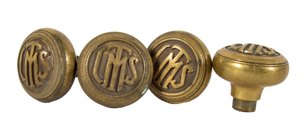 group of four matching interior logan square masonic temple building monogrammed cast brass doorknobs with nicely aged surface patina