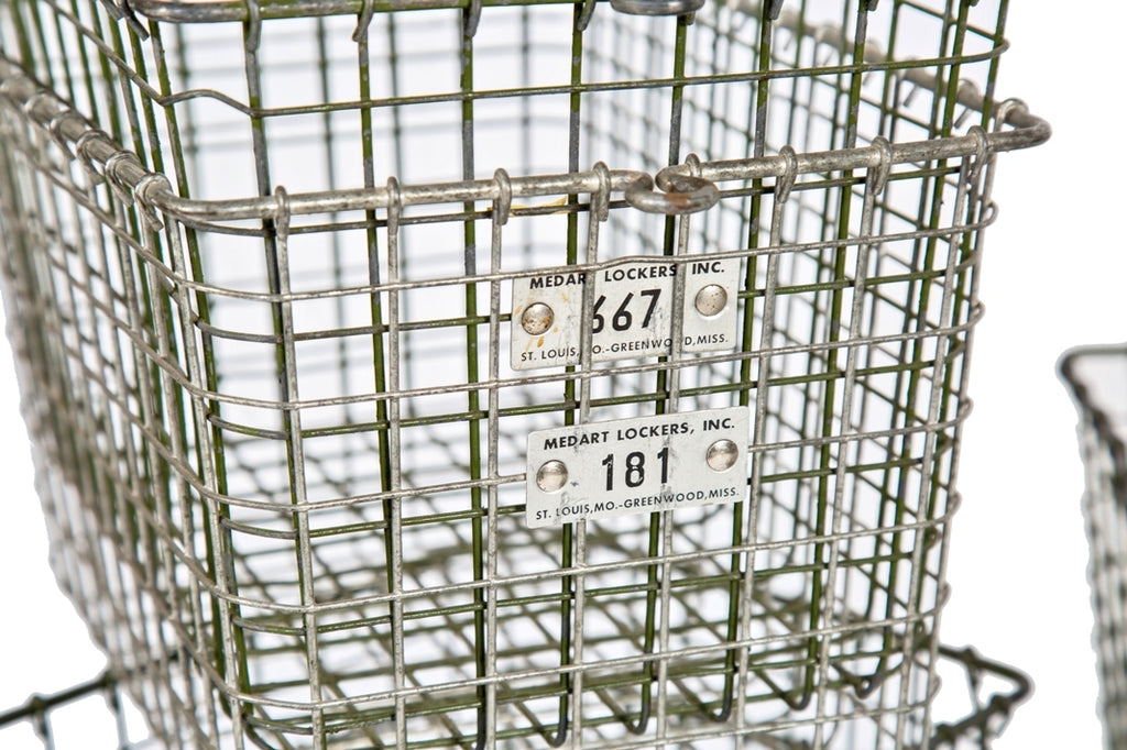 several matching vintage american industrial salvaged "medart" metal wire locker room baskets with numbered aluminum number tags