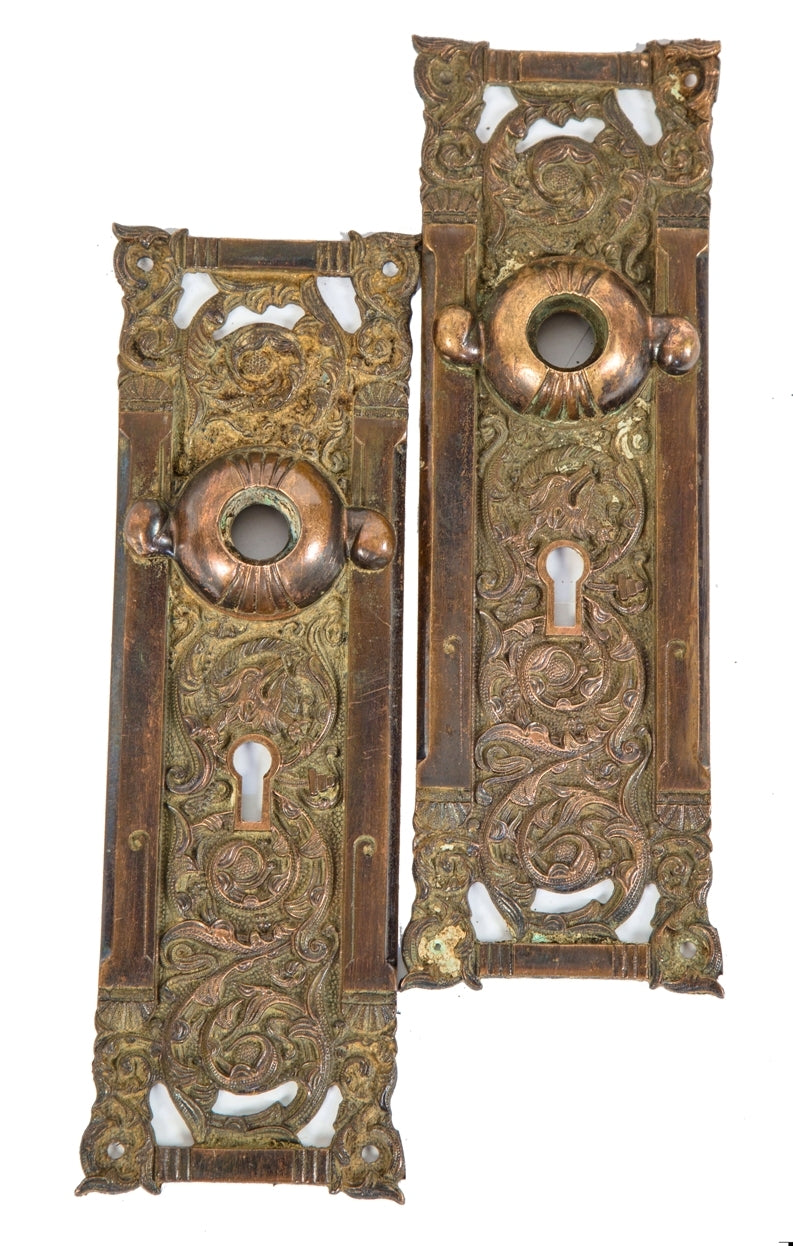 two matching original highly desirable ornamental cast bronze "columbian" pattern interior residential passage door backplates with finely designed casting detail