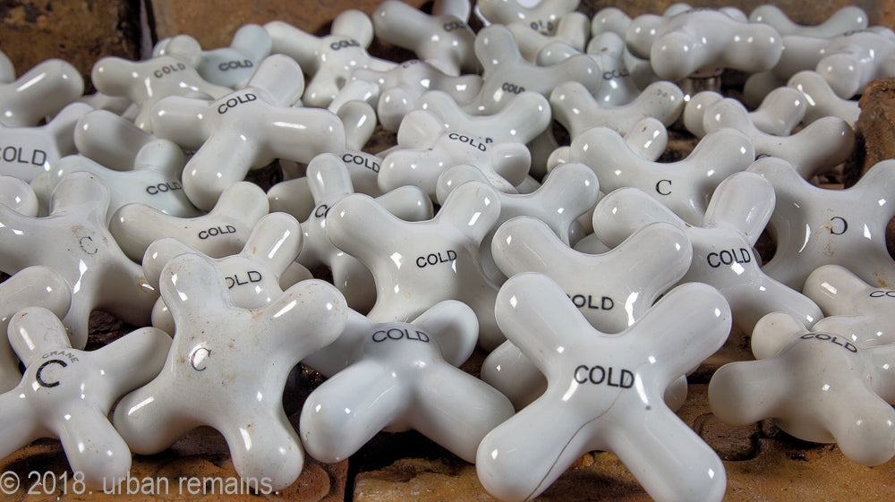 huge lot of salvaged chicago late 19th century and early 20th century interior residential bathroom sink, bathtub, and shower cross-arm "cold" faucet handles with black lettering