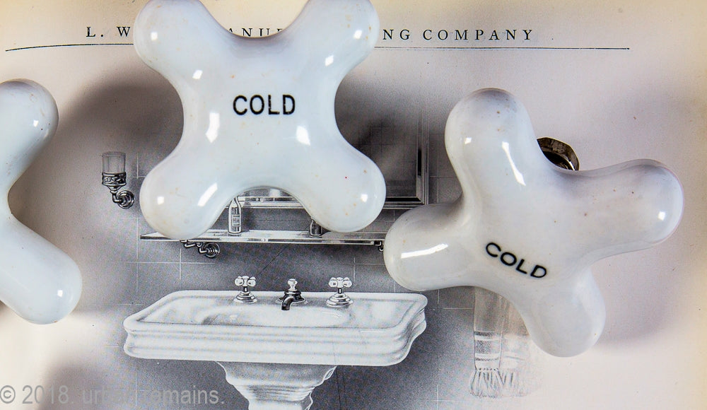 huge lot of salvaged chicago late 19th century and early 20th century interior residential bathroom sink, bathtub, and shower cross-arm "cold" faucet handles with black lettering