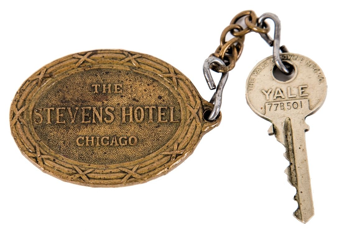 early ornamental cast brass downtown chicago stevens hotel emblematic oval-shaped key fob with rearing lion, shield, and ribbon with hotel name