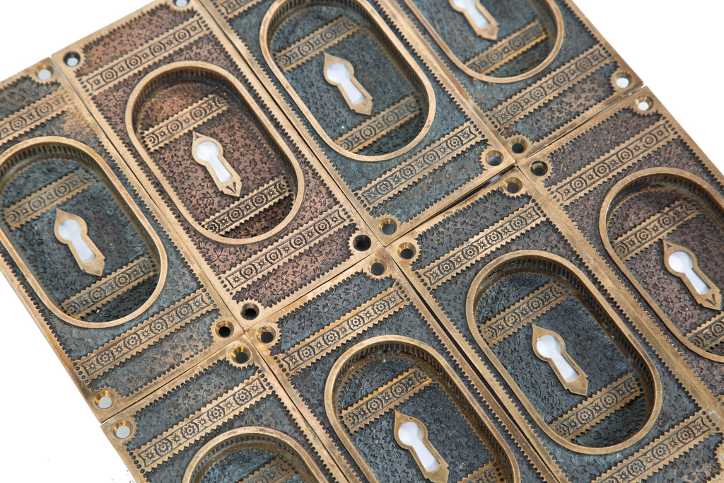 large group of hard to find and highly sought after "ivy" pattern american eastlake style cast bronze interior residential pocket door handles with nicely aged patina