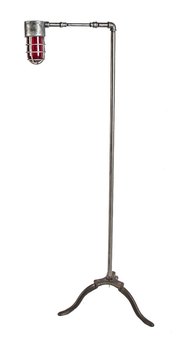 repurposed three-legged brushed steel "explosion proof" floor lamp with ruby red globe and threaded cage