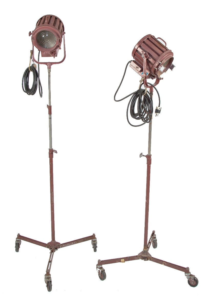 two matching vintage american industrial fully adjustable studio stage set spotlights with three-legged mobiles stands