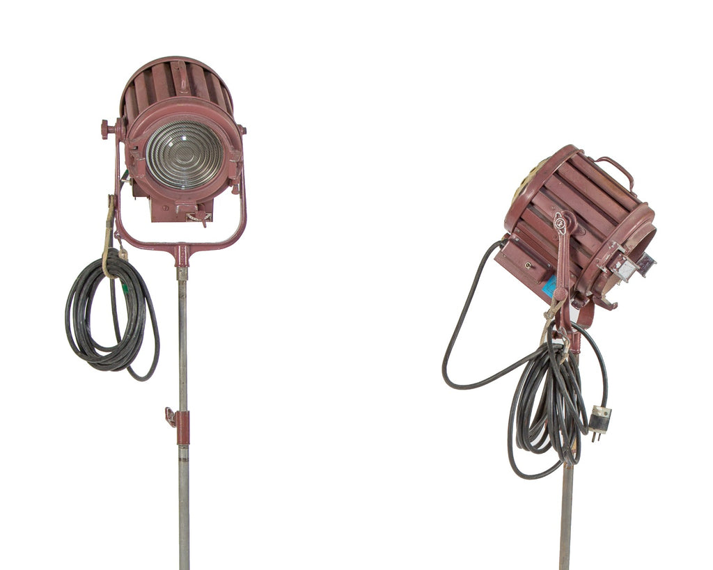 two matching vintage american industrial fully adjustable studio stage set spotlights with three-legged mobiles stands