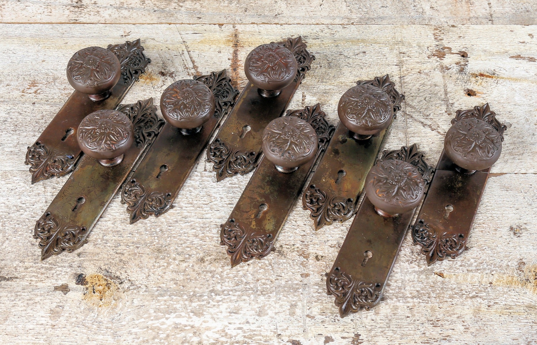 group of matching late 19th or early 20th century antique american "panama" pattern salvaged chicago doorknobs and matching backplates