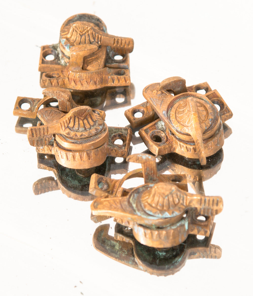 group of four original ornamental cast brass interior residential eastlake style sash locks with matching keepers