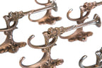 group of six matching original ornamental cast iron figural grotesque oversized parlor or hall tree hooks with traces of copper-plated finish
