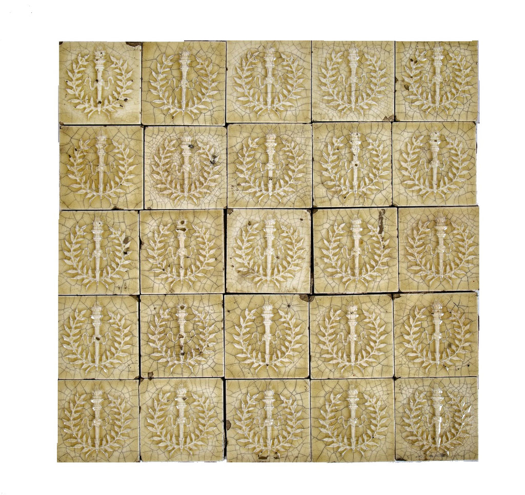 original 19th century 3 x 3 inch yellow glazed deeply embossed majolica tiles with torches and laurel wreaths