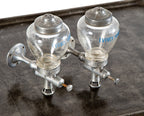 one of two identical antique american art deco wall-mount ivory soap glass dispensers with functional plunger
