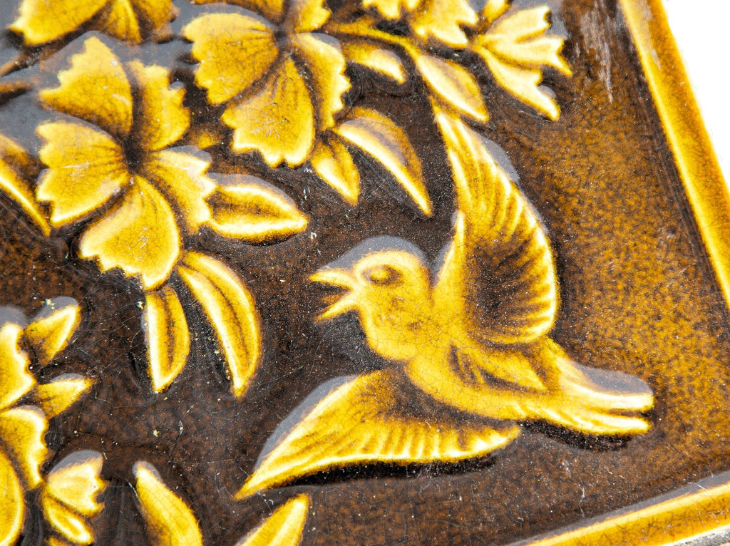 19th century salvaged figural 6 x 6 fireplace tile featuring floral designs and winged bird with rich olive glazed finish