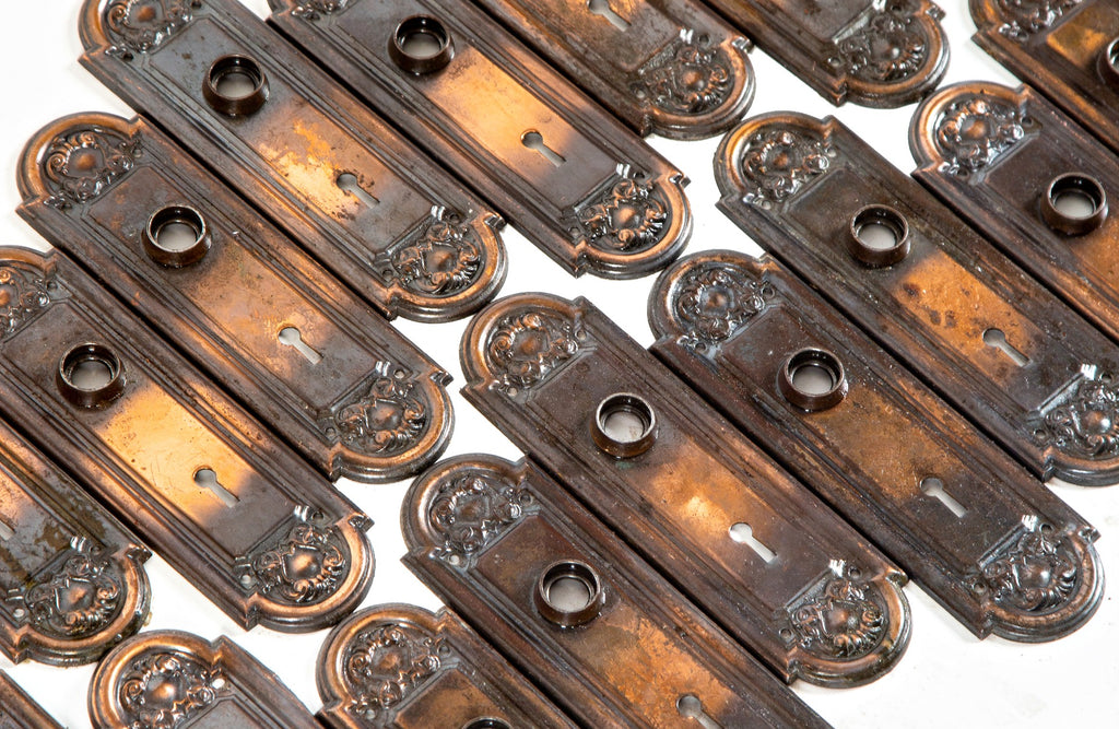 large lot of original early 20th century antique american stamped ornamental steel passage door backplates with oxidized copper-plated finish