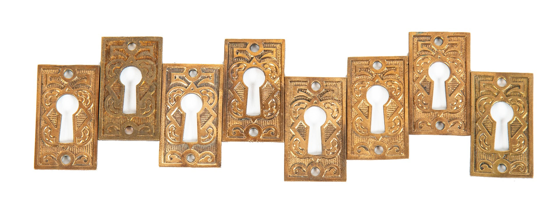 group of 19th century ornamental cast brass american victorian-era passage door keyhole backplates or escutcheons