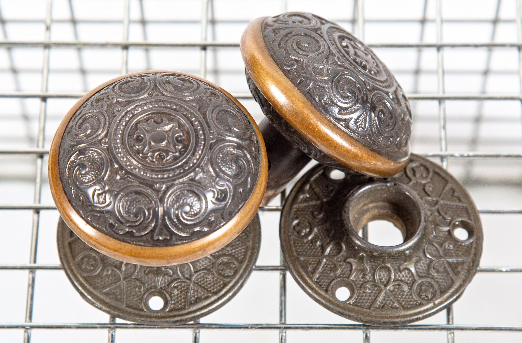 hard to find and highly stylized 1870s ornamental cast iron and brass doorknobs and matching rosettes salvaged from a post-fire chicago cottage