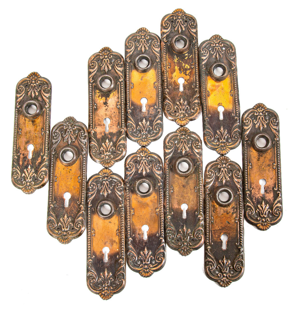 large lot of matching early 20th century salvaged milwaukee copper-plated stamped steel doorknob backplates