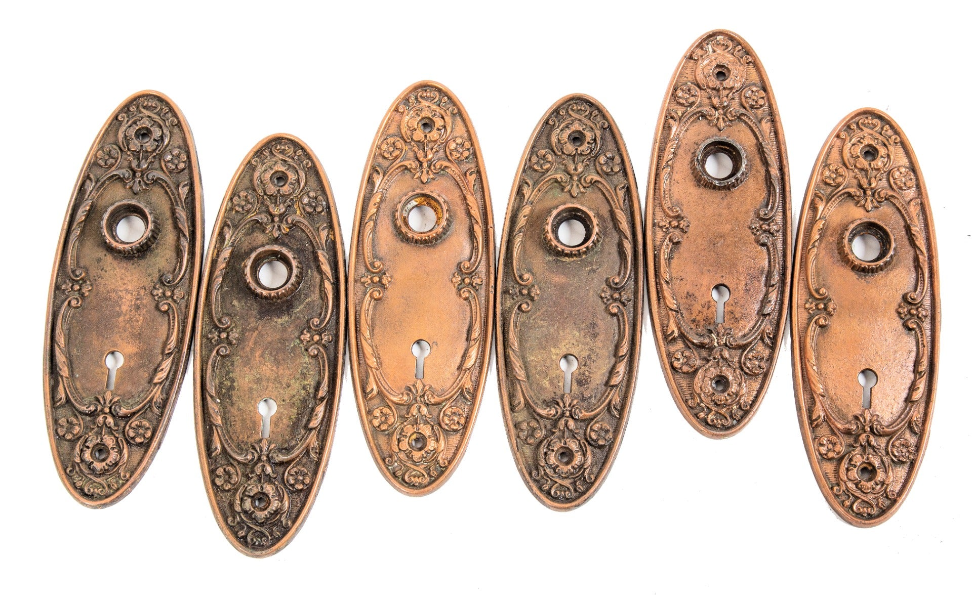 group of original early 20th century antique american interior residential ornamental copper-plated cast iron "arcadia" pattern doorknob backplates