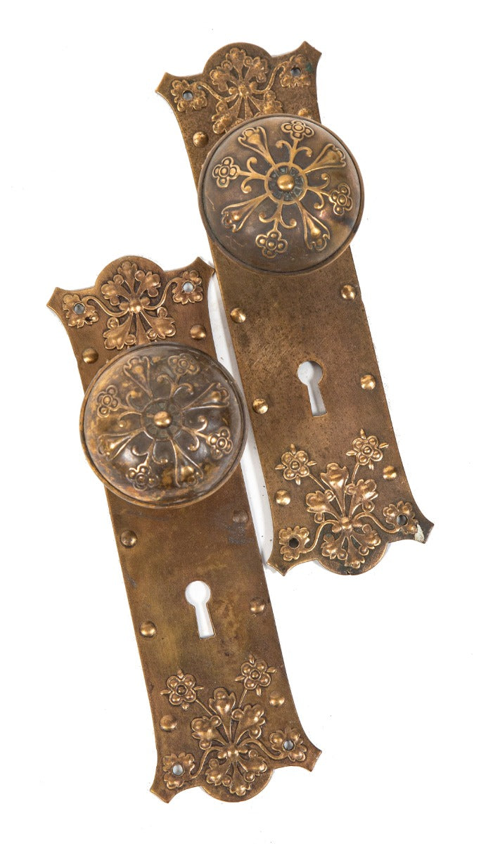 matching lot of original early 20th century ornamental interior residential wrought bronze doorknobs and matching backplates