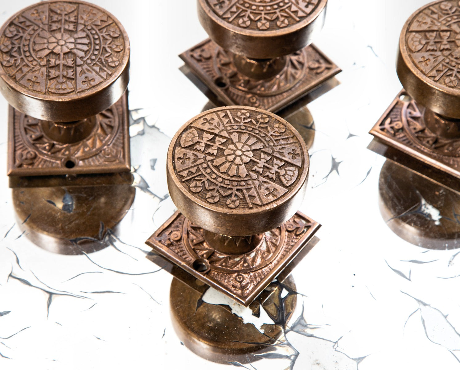 group of highly desirable antique american eastlake style ornamental cast bronze penn drum-shaped doorknobs and matching rosettes