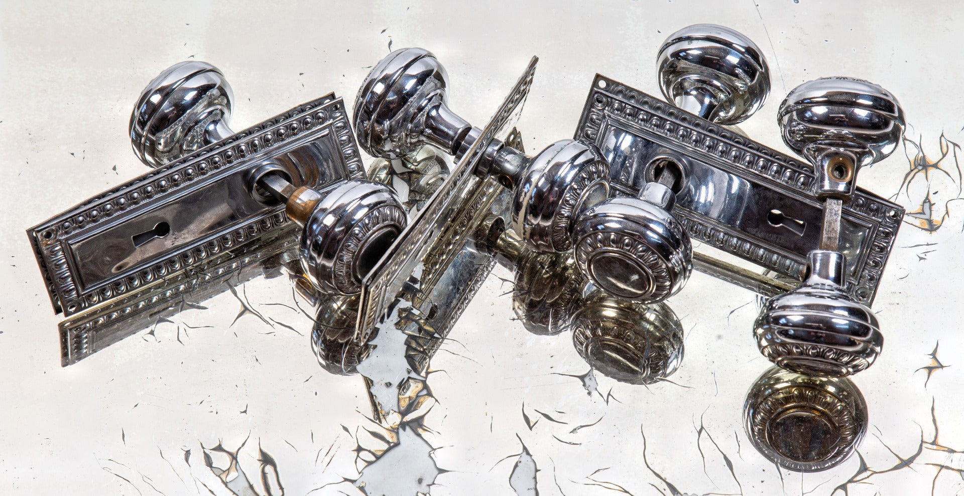 group of early 20th century salvaged chicago chrome-plated stamped brass egg and dart pattern doorknobs and matching backplates
